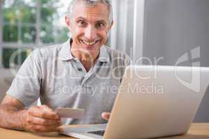 Smiling mature man using his laptop
