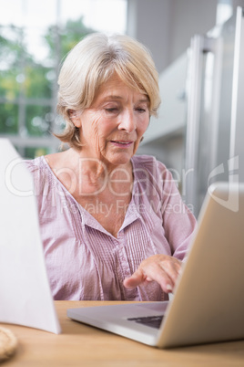 Mature woman touching her laptop