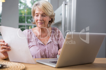 Smiling mature woman using her laptop