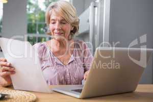 Smiling mature woman using her laptop