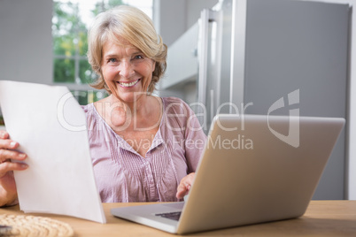 Happy mature woman using her laptop