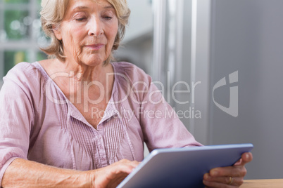 Mature woman touching her digital tablet