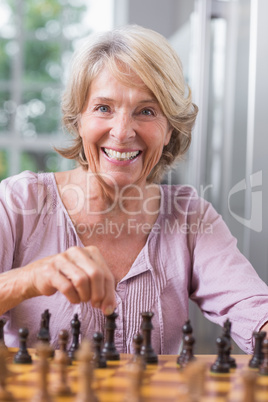 Happy woman playing chess