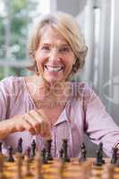 Happy woman playing chess
