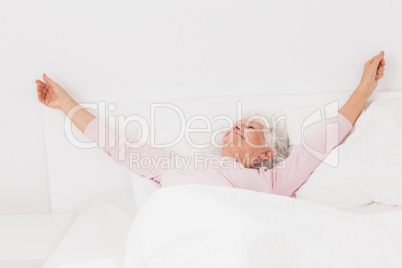 Woman stretching in bed