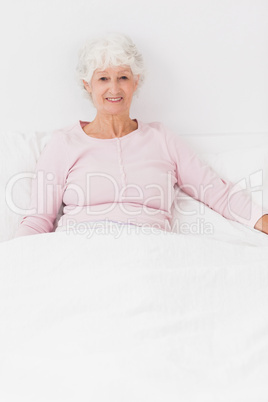 Smiling woman sitting in bed