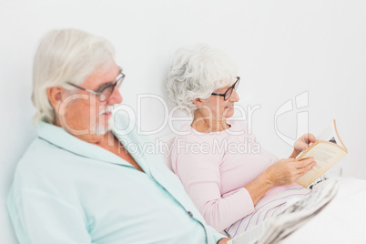 Husband and wife reading in bed