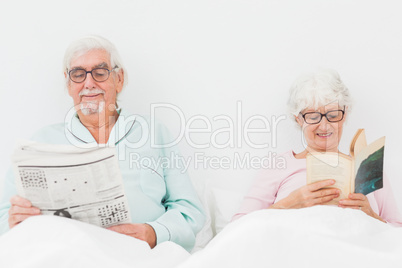 Happy couple reading in bed Happy couple reading in bed