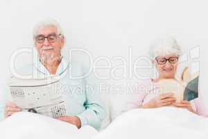 Happy couple reading in bed