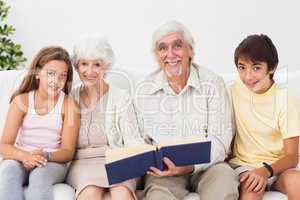 Smiling grandparents with grandchildren reading