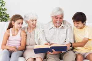 Grandparents reading book with grandchlidren