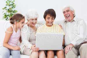 Grandparents and grandchildren using laptop