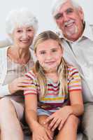 Granddaughter with grandparents on the sofa