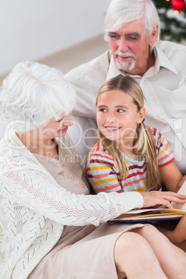 Grandparents with granddaughter reading