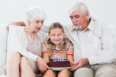 Little girl with grandparents celebrating birthday