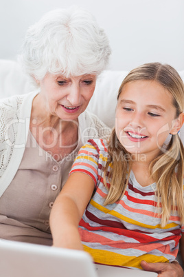 Little girl and granny using laptop