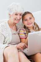 Happy girl using laptop with granny