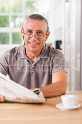 Smiling man reading a newspaper