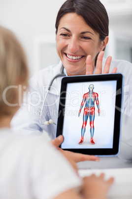 Smiling doctor showing a tablet computer to a child