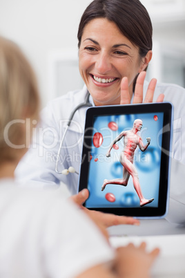 Smiling doctor showing a tablet computer to a child