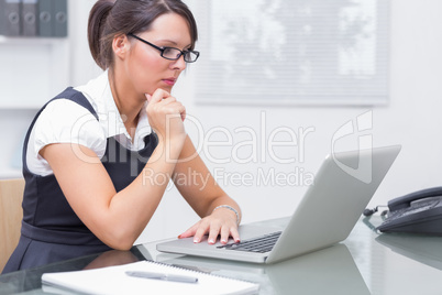 Woman working on her computer with pair of glasses