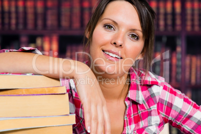 Girl leaning on books with a smile