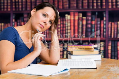 Woman thinking with pen and book