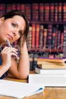 Cute woman thinking with pen and book