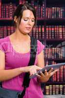 Woman touching tablet in library