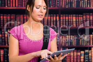 Girl touching a tablet in library