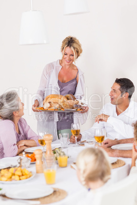 Mother bringing turkey to dinner table