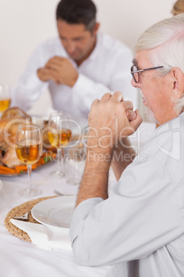 Family saying grace before eating