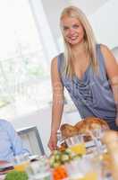 Smiling woman bringing turkey to the table
