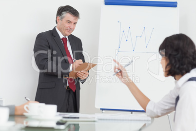 Businessman writing on clipboard in office