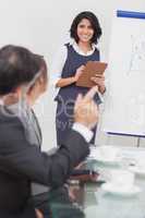 Man posing a question to his businesswoman with clipboard