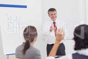 Businessman pointing to colleague raising her hand with big smil