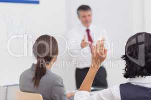 Businessman pointing to his colleague raising her hand