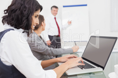 Businesswoman using a laptop during a conference