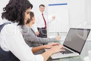 Businesswoman using a laptop during a conference