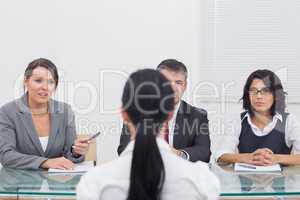 Three business people folding hands in small meeting