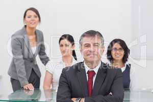 Portrait of  happy businessman with team