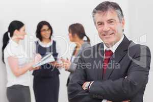 Businessman smiling and three businesswomen speaking