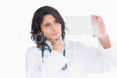 Doctor holding up virtual screen and touching the chin