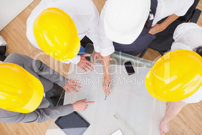 Team looking at a construction plan with hard hats