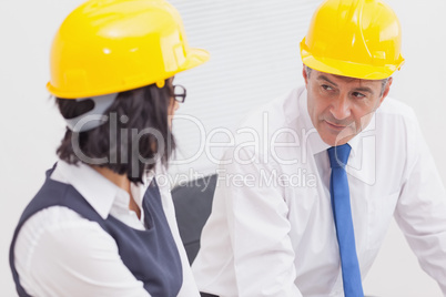 Two architects speaking with yellow helmet