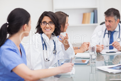 Two doctors speaking with two nurses