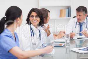 Two doctors speaking with two nurses