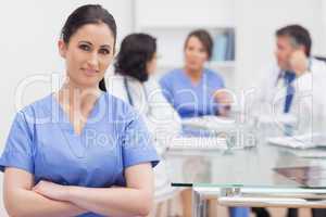 Nurse with arms crossed and her team