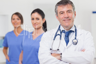 Doctor with stethoscope smiling and his team