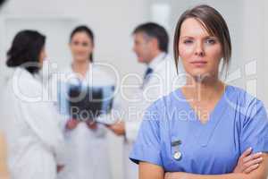 Nurse standing seriously with her team